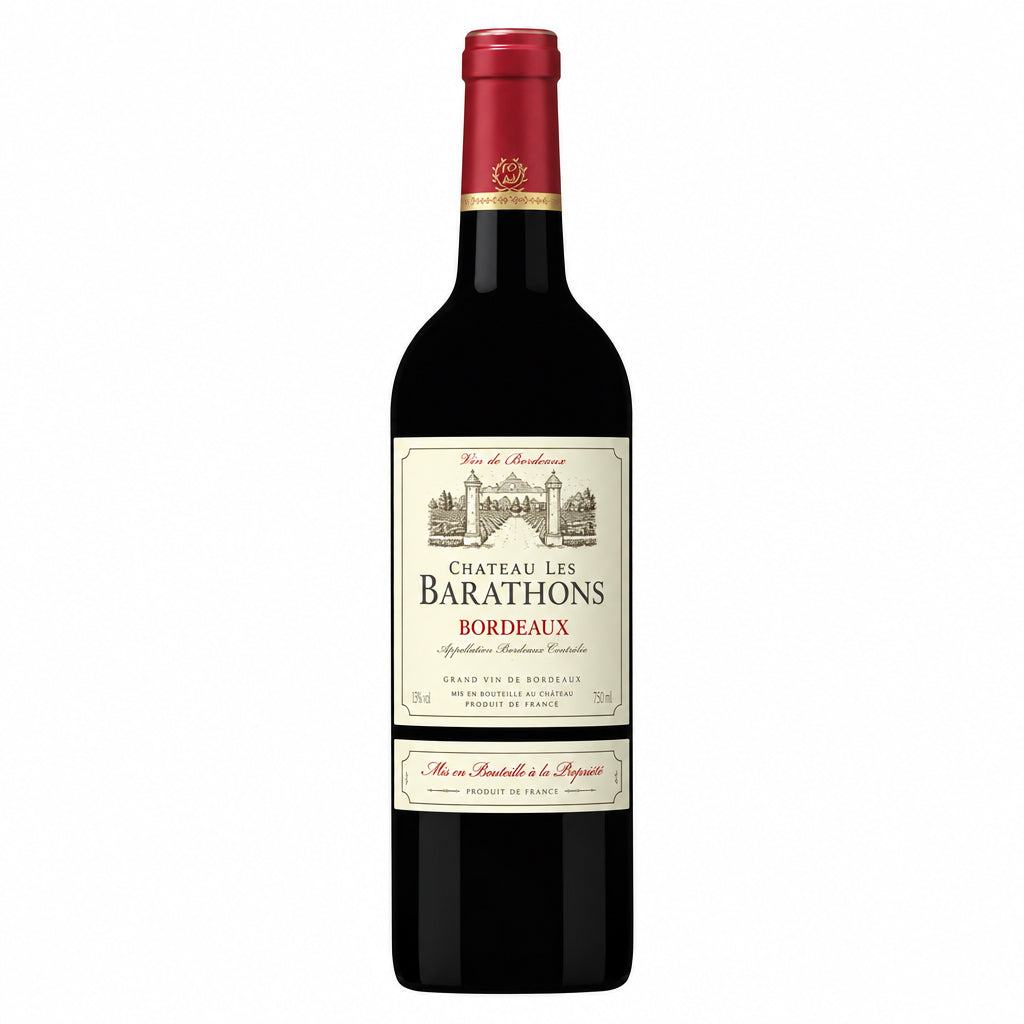 Bottle of Chateau Les Barathons red wine with a label, placed on a wooden surface with a blurred background.