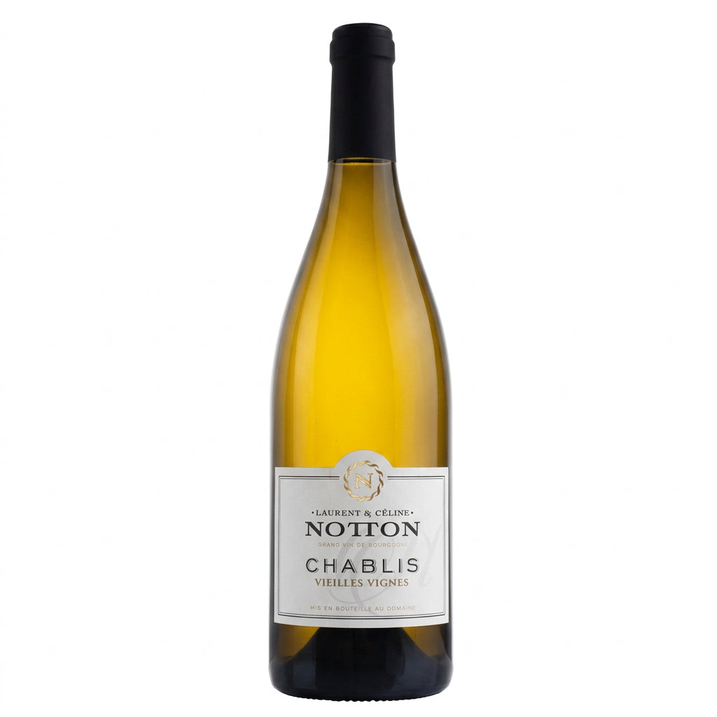 Domaine Laurent & Celine Notton Chablis Vieilles Vignes wine bottle on a wooden surface with greenery background.