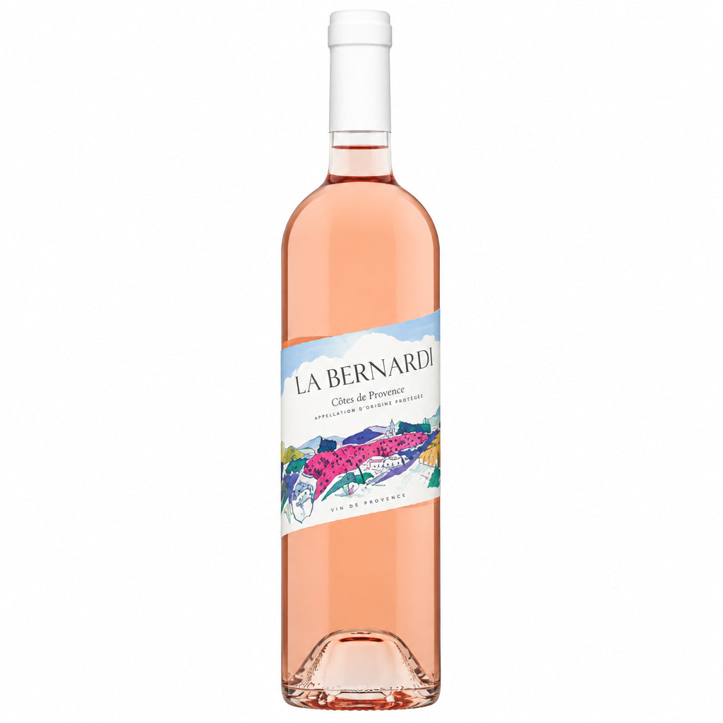 Bottle of La Bernarde Cotes De Provence Rosé wine with a pink hue and label, placed on a rustic wooden table.