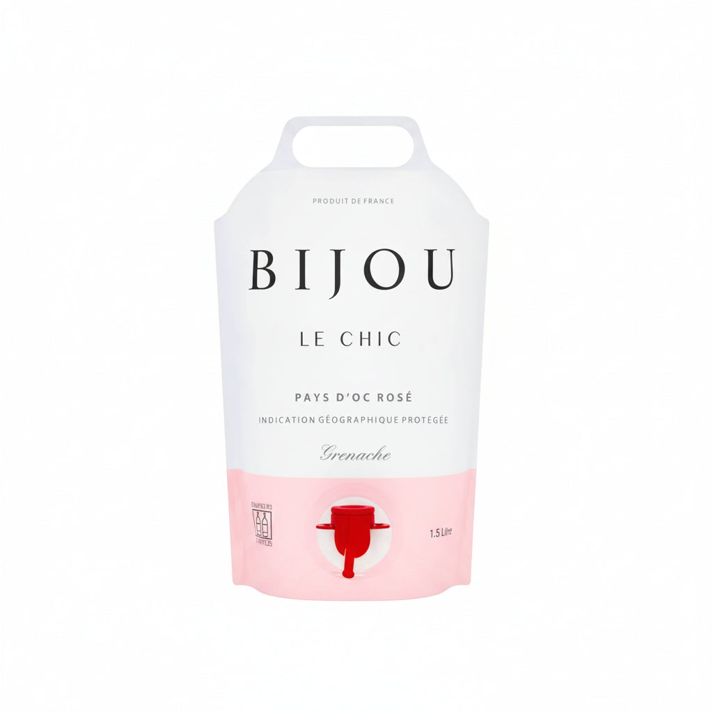 Bottle of Bijou Le Chic Grenache Rosé 1.5L wine with pink hue and elegant label, displayed on a wooden surface.