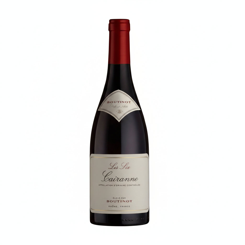 Boutinot Les Six Cairanne red wine bottle with label showing, placed on a wooden surface with a blurred background.