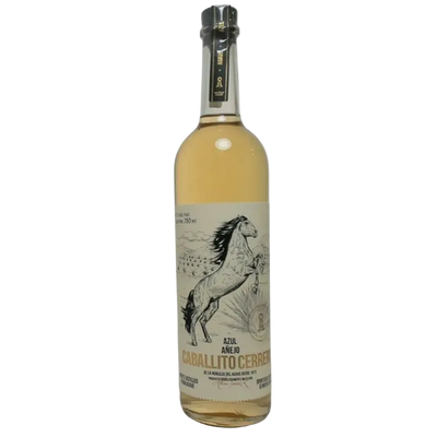 Blue Caballito Cerrero Añejo tequila bottle, 750mL, with colorful label and distinctive design, on a wooden surface.