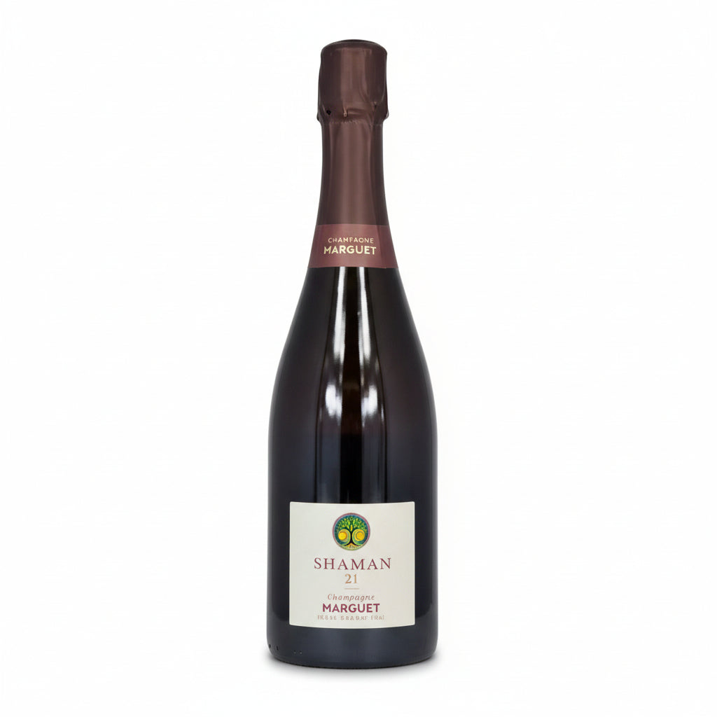 Champagne Marguet Shaman Grand Cru Blanc bottle with elegant label and sparkling golden liquid in a flute glass.