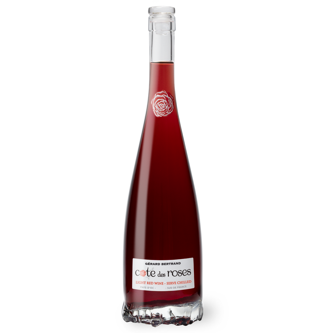 Light red Gerard Bertrand Cote Des Roses wine in a clear glass, showcasing its delicate color and elegant presentation.