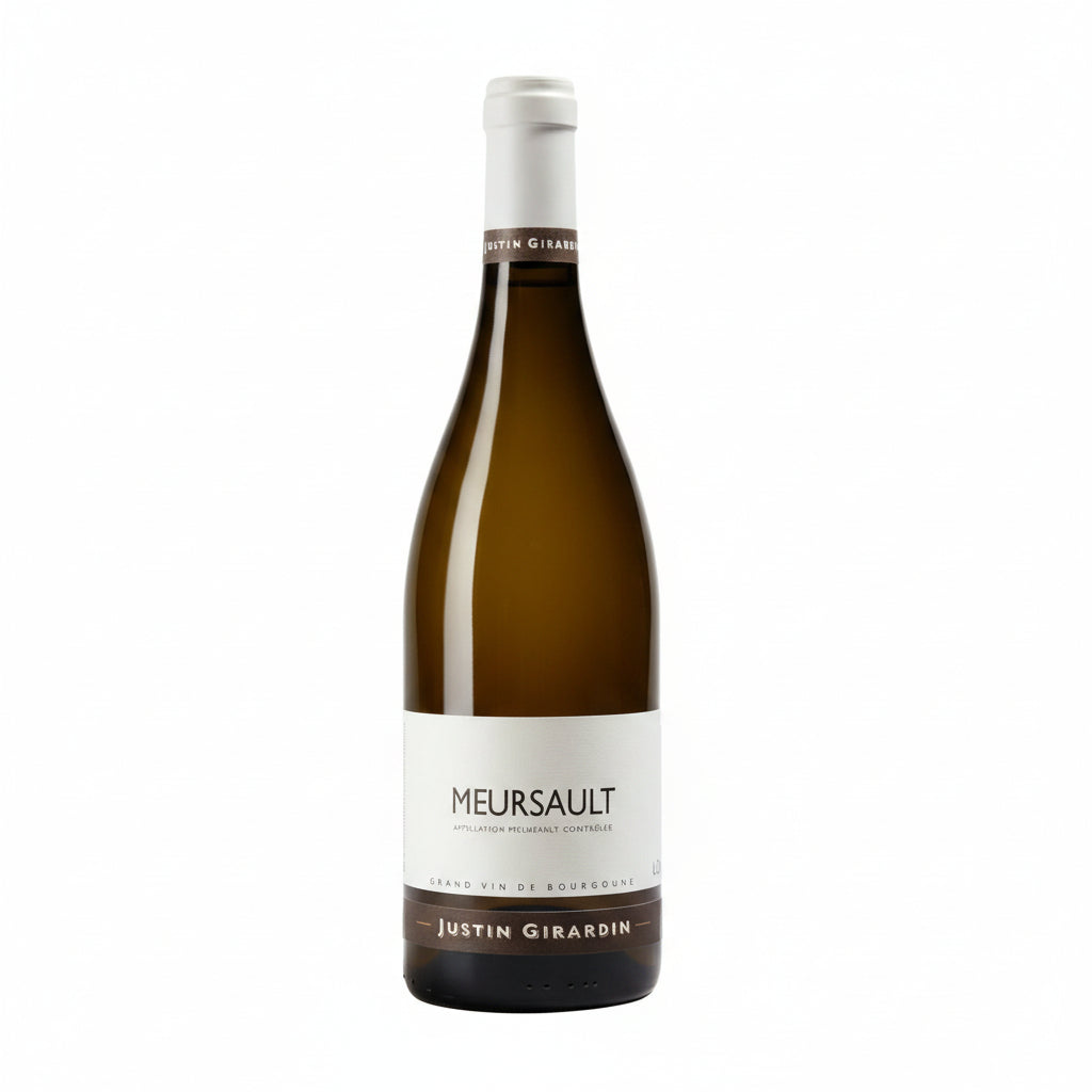 Bottle of Justin Girardin Meursault white wine with label visible, elegant glass, and cork in a natural setting.