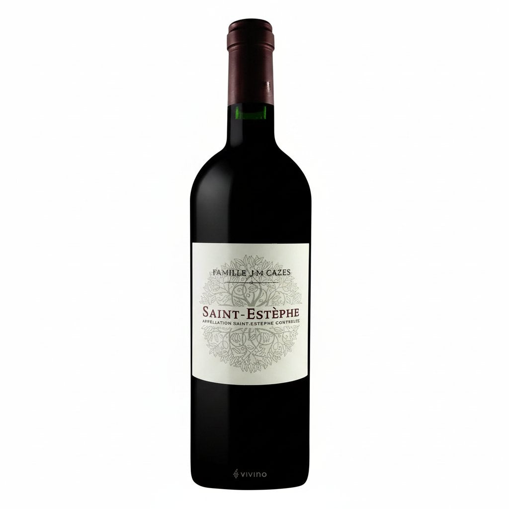 Bottle of Famille JM Cazes Saint Estephe red wine with label visible, displayed on a wooden surface.