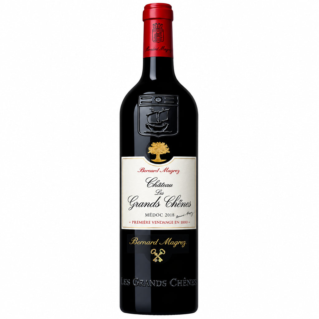 Bottle of Chateau Les Grands Chenes Medoc red wine with label visible, standing upright on a wooden surface.