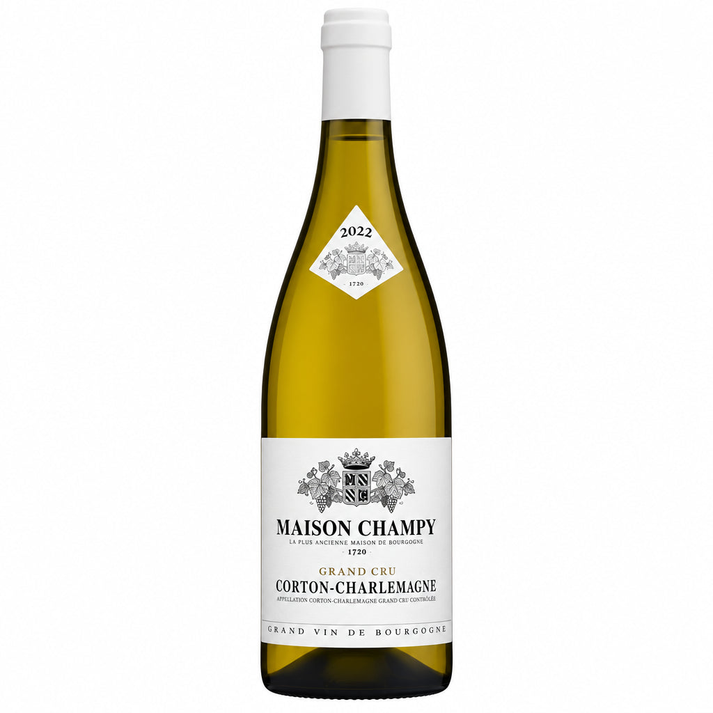 Bottle of Champy Corton Charlemagne Grand Cru white wine with a white label and gold foil, standing upright on a wooden surface.