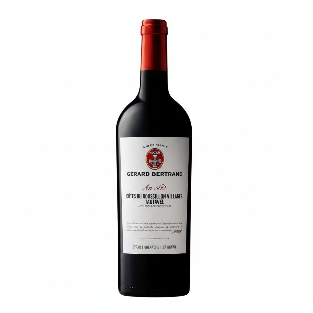 Gerard Bertrand An 560 Cotes du Roussillon Villages Tautavel wine bottle with label and glass on a wooden table.