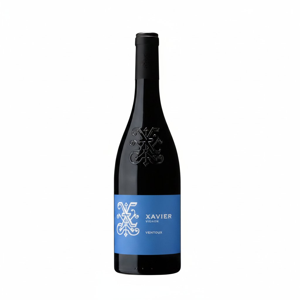Bottle of Xavier Vins Ventoux red wine with label visible, cork and glass nearby, on a wooden surface.